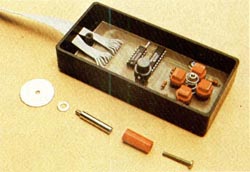 La placa principal se fija a la caja mediante dos tornillos con arandela, haciendo pasar la cinta de cables que conexiona con el Spectrum por una ranura practicada en el lateral.